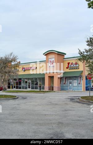 Florida, USA - March 23, 2024: Colorful image showing a barbershop next to a seafood restaurant, both with vibrant signs, inviting potential customers Stock Photo