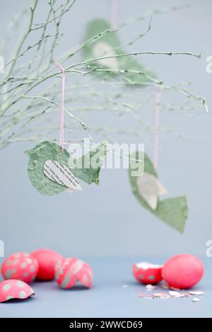Cracked Easter eggs and twigs decorated with paper birds Stock Photo