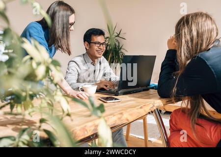 Smiling IT technician discussing with colleagues at creative office Stock Photo