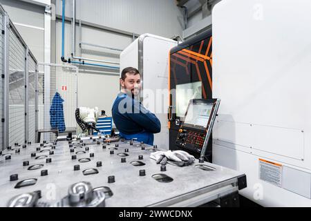 Smiling maintenance engineer working in modern factory Stock Photo
