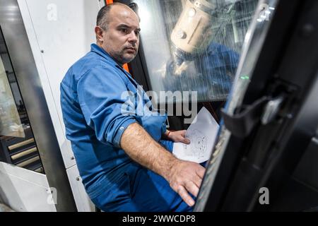 Technician operating machinery in industry Stock Photo
