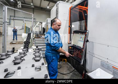 Maintenance engineer operating robotic machinery in modern factory Stock Photo