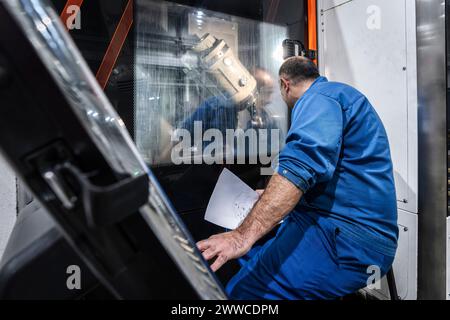 Technician operating machinery in modern factory Stock Photo