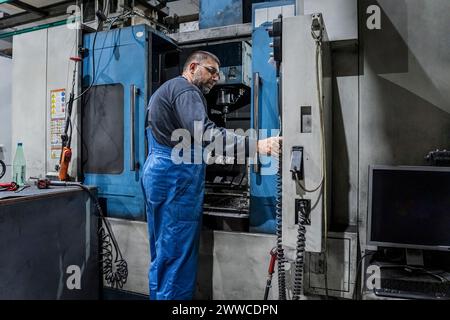 Mature technician operating machinery in industry Stock Photo