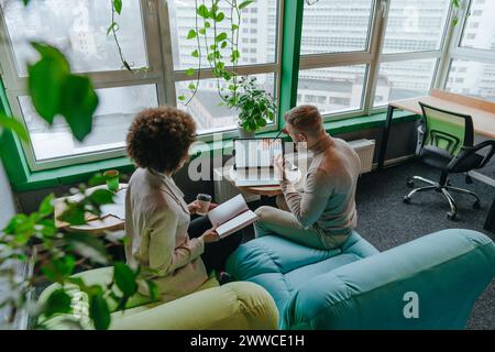 Multiracial colleagues discussing graph on laptop in meeting at coworking office Stock Photo