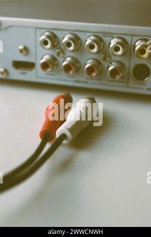 Rear panel of a multimedia player with ejected plugs on video cable in old film style Stock Photo