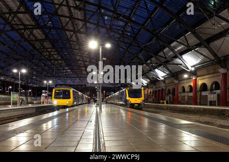 Northern Rail class 331 (right) and class 323 (Left) electric multiple unit train under the roof at Liverpool Lime Street railway station at night Stock Photo