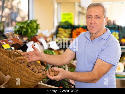 man buy large walnuts in supermarket Stock Photo