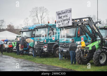 Kaiserslautern, Germany. 23rd March, 2024. Trucks, tractors and people standing in heavy rain during protest rally. The protest starts with a rally at Messeplatz (Square) and continues with a convoy drive through the city.  Participants from different industries are welcome to join the demonstration against the current government. Credit: Gustav Zygmund/Alamy News Stock Photo