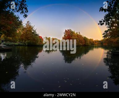 19/010/13 The sun makes a brief appearance creating a magical circular rainbow as it is reflected in Ashbourne Park lake, on the edge of the Derbyshir Stock Photo