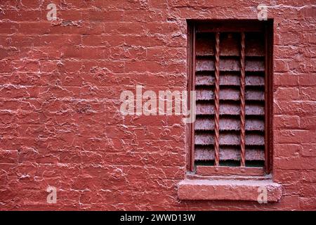Vented Opening in a Painted Red Brick Wall Stock Photo