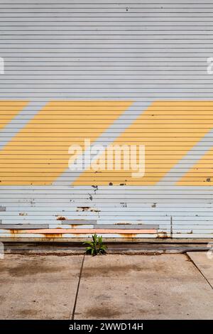 Vertical View of Closed Grey Garage Door with Yellow Diagonal Stripes Stock Photo