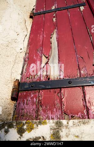 Peeling Red Paint on Window Shutter Stock Photo