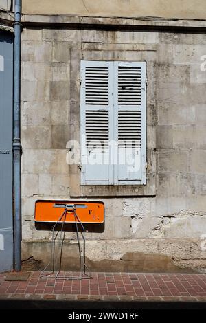 Closed Grey Shutters and Small Orange Folding Table Stock Photo