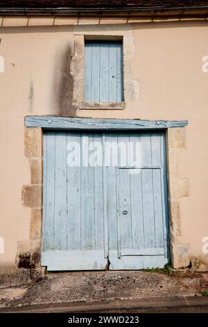 Closed Large Door with Small Inset Door with Window Shudder Above Stock Photo