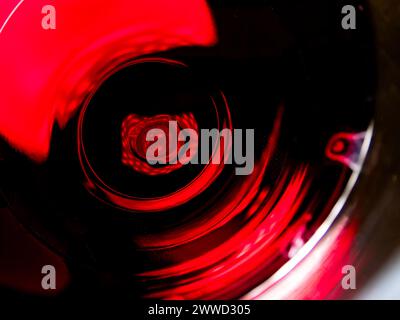 Artistic close-up of an illuminated red wine glass on a black background Stock Photo