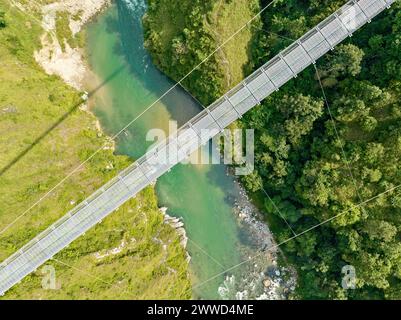 Aerial view of a Tibetan suspended bridge in Nepal is a primitive type of bridge. Wild nature, rice fields, valleys and rivers Stock Photo