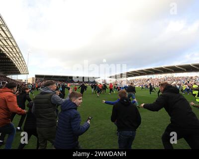 Chesterfield, UK. 23rd Mar, 2024. Chesterfield fans spill onto the pitch as they celebrate winning the National League during the Chesterfield FC v Boreham Wood FC Vanarama National League match at the SMH Group Stadium, Chesterfield, England, United Kingdom on 23 March 2024 Credit: Every Second Media/Alamy Live News Stock Photo