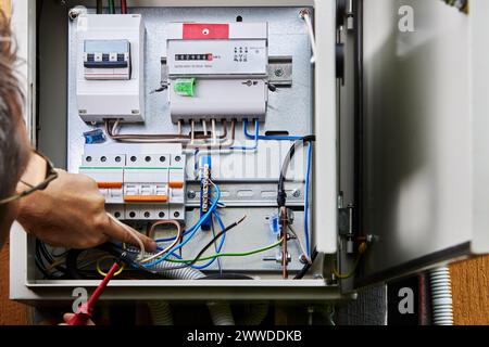 Connecting three-phase power cable for outdoor distribution board, during wiring installation in country house. Stock Photo