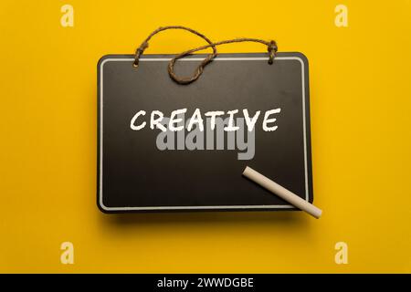 A small chalkboard for schedules on orange background with Creative words Stock Photo