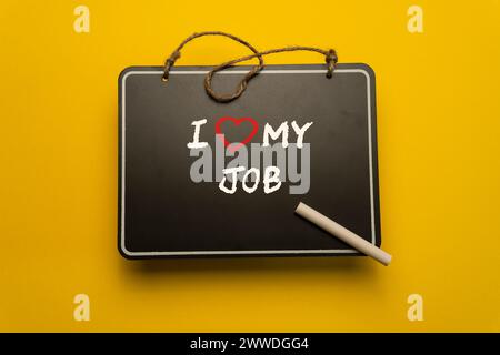 A small chalkboard for schedules on orange background with I love my job words Stock Photo