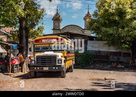 A colorful chicken bus with a Masaya-Granada route sign parked in a Nicaraguan town Stock Photo