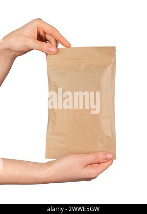 Hand holding zip-lock kraft paper bag. Ziplock pouch, craft eco package, soft pack isolated on white background Stock Photo