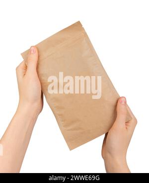 Hand holding ziplock paper bag. Zip-lock pouch, kraft eco package, craft soft pack isolated on white background Stock Photo