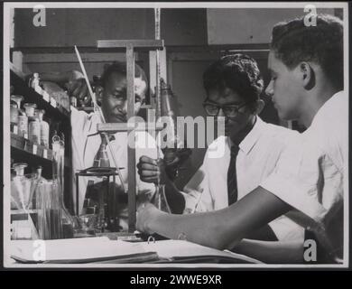 Secondary school science class in Grenada, Windward Islands, showing students performing a chemistry experiment, illustrating educational facilities and teacher training available in the region in April 1961. Stock Photo