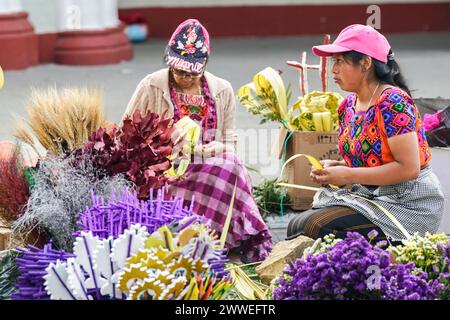 Antigua, Guatemala. 23rd Mar, 2024. Indigenous Mayan families make palm bouquets for Palm Sunday as devotees line up to pray at the vigil for Jesus at the Santuario San Felipe de Jesús, March 23, 2024 in Antigua, Guatemala. The opulent processions, detailed alfombras and centuries-old traditions attract more than 1 million people to the ancient capital city. Credit: Richard Ellis/Richard Ellis/Alamy Live News Stock Photo