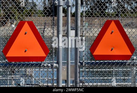 warning triangles on cyclone fence at a Alameda County Water District facility along the Alameda Creek, Fremont, California Stock Photo