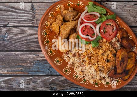 Rice congri with pork fricassee, salad and fried ripe plantain. Typical ...