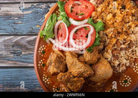 Rice congri with pork fricassee, salad and fried ripe plantain. Typical ...