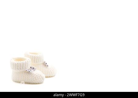 White crochet baby booties with black polka dot bows isolated on a white background. Handmade baby booties. Photo in high quality Stock Photo