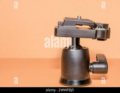 Closeup side view of quick release tripod head on brown background Stock Photo