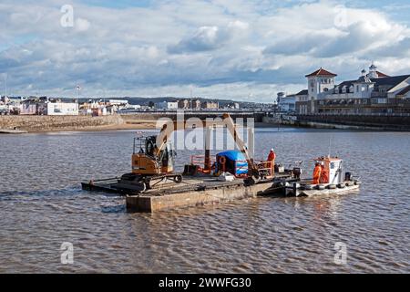 Dredging to remove excess mud from the Marine Lake in Weston-super-Mare, UK on 26 February 2024. Weston-super-Mare is situated on the Bristol Channel, which has one of the highest tidal ranges in the world, and regular dredging is required to ensure that the Marine Lake remains usable for swimming. Stock Photo