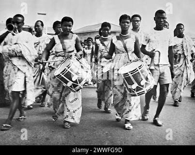 Accra, Ghana, July 18, 1961 Sparked by the patriotic fervor of Ghana Republic Day, these costumed lady drummers lead a procession in Accra. Stock Photo