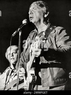 May 20, 1976 Buck Owens playing guitar and singing on stage during a concert. Stock Photo