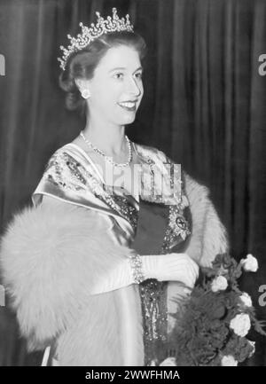 A photograph captures Princess Elizabeth II arriving at the Guildhall for the banquet launching the Lord Mayor's National Thanksgiving Fund in 1950. This event marks a significant public appearance, showcasing her involvement in national efforts and her role in supporting charitable initiatives, set against the backdrop of post-war Britain's recovery and renewal. Stock Photo