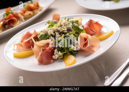 Restaurant menu. Summer pear salad with jamon, blue cheese and spinach on white table Stock Photo