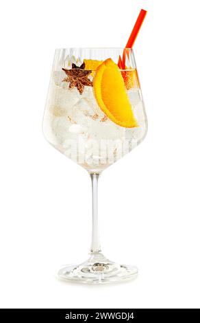 Crystal balloon glass of vodka tonic garnished with star anise and orange isolated on white background. Stock Photo