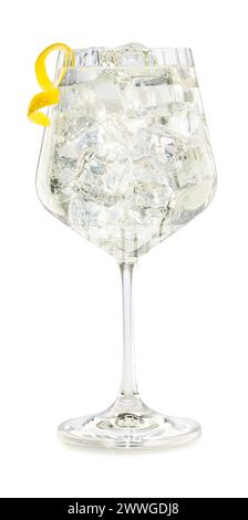 Gin tonic in crystal balloon glass garnished with lemon twist zest isolated on white background. Stock Photo