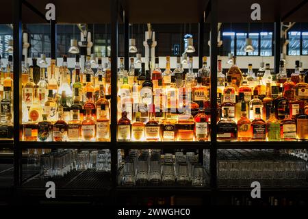 Wide Array of Liquors on Illuminated Shelves at Time Out Market in Lisbon, Portugal. February 2, 2024. Stock Photo