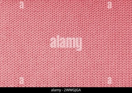Close up background of knitted wool fabric made of viscose yarn, red color wool knitwear texture. Sweater, pullover knitted jersey background. Fabric Stock Photo