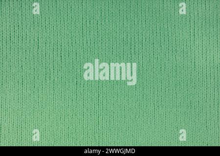 Green knitted woolen jersey fabric, sweater, pullover texture background. Fabric abstract backdrop, cloth wallpaper Stock Photo