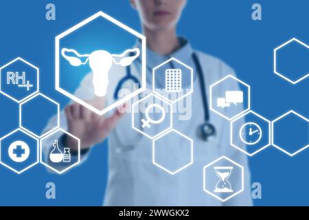 Menopause concept. Doctor touching uterus icon on digital screen against blue background, closeup Stock Photo