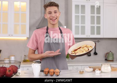 Smiling food blogger explaining something in kitchen Stock Photo
