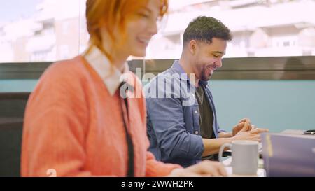 Coworkers smiling while working together with computers Stock Photo