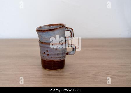 Two stacked handmade glazed ceramic coffee cups. High quality photo Stock Photo