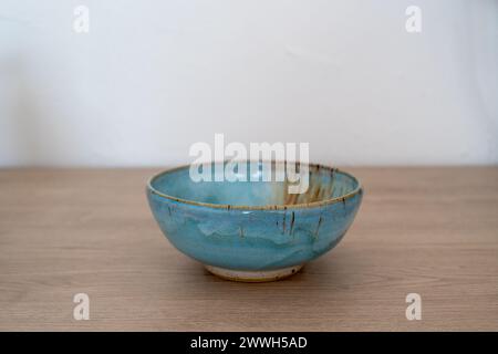 Handmade glazed blue ceramic bowl on wood counter. High quality photo Stock Photo
